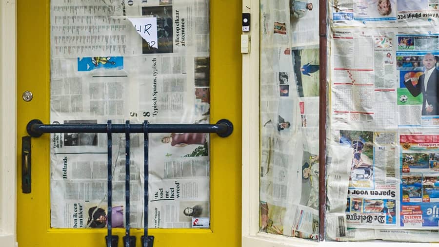 Porte dont la fenêtre est recouverte de journaux