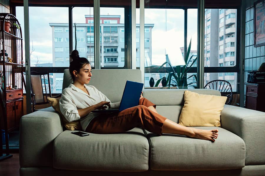 Vrouw op bank met laptop