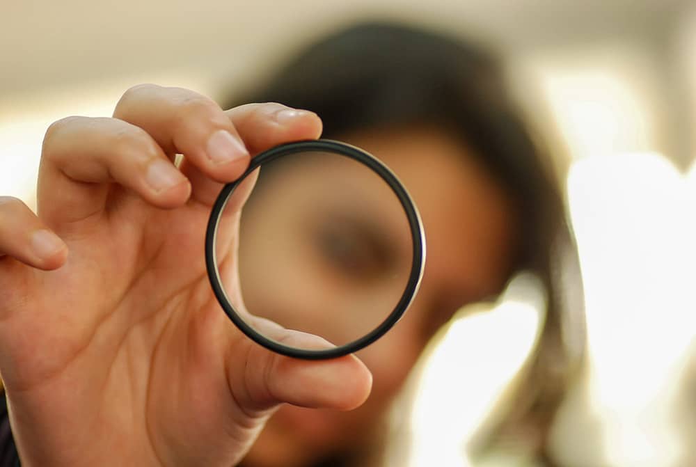 personne qui tient un verre de loupe